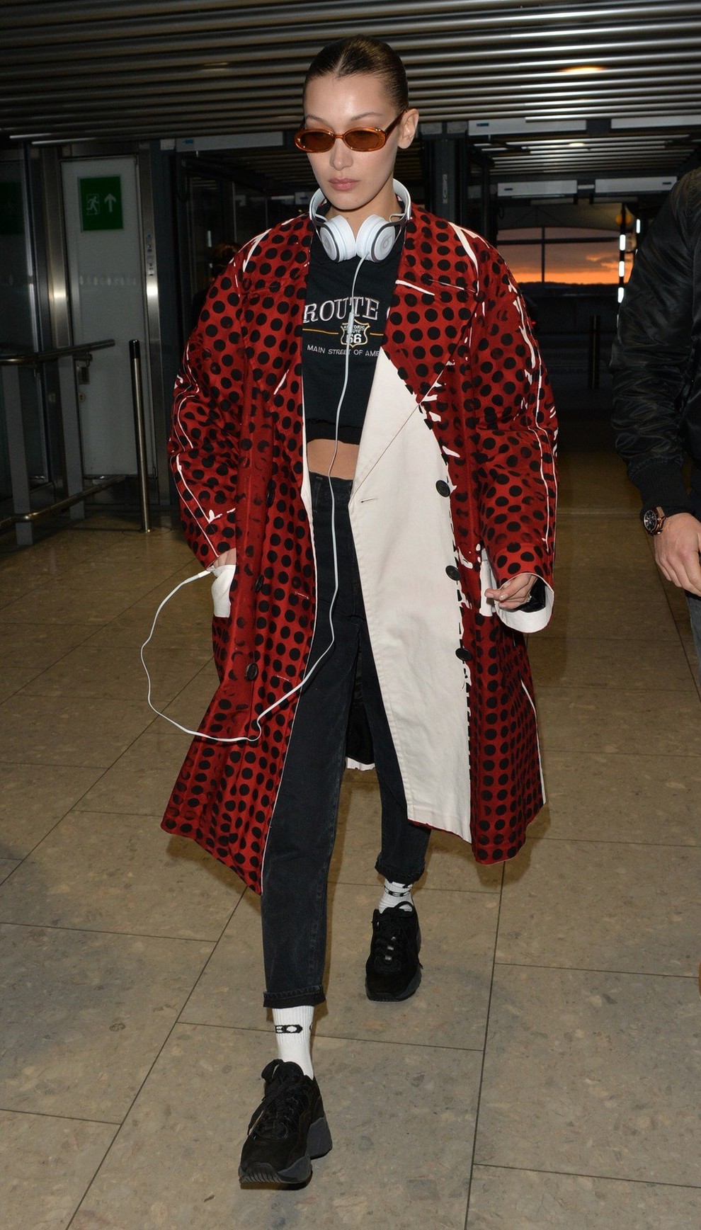 Bella Hadid se je na letalo odpravila v oversized temno rdečem plašču na pike.