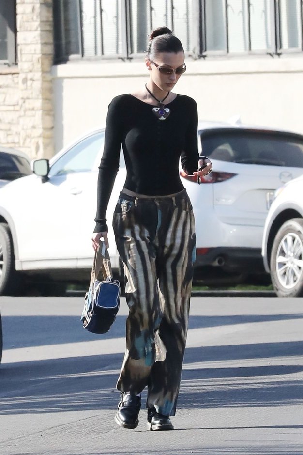 Bella Hadid je tie dye hlače postavila v središče stajlinga. Barvne hlače je kombinirala z oprijetim črnim topom in kompaktno …