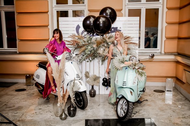 Nasmejani hostesi v kotičku podjetja PVG, kjer smo občudovali mestno junakinjo Vespo. Za vzdušje praznovanja magične noči pa je z baloni poskrbela trgovina Arbadakarba. (foto: Aleksandra Saša Prelesnik)