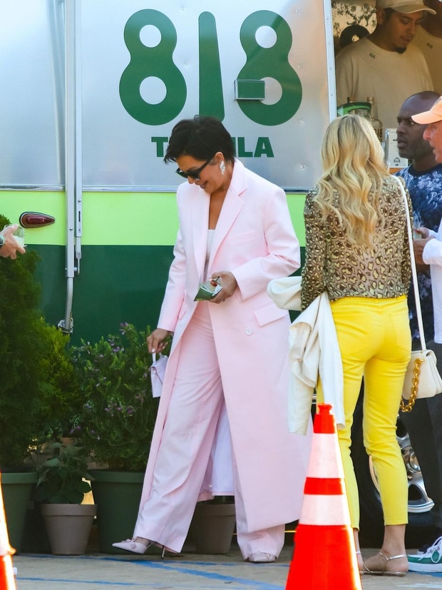 Nosila je rožnat dolg plašč z belimi gumbi in hlače v isti barvi. Mati klana Kardashian-Jenner je svoj videz zaključila …