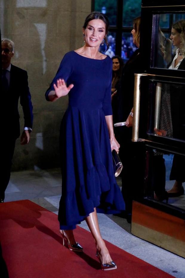 Nosila je temno modro koktajl obleko španske znamke Miphai. Obleka z voluminoznim spodnjim delom, okrašenim z volančki, je spredaj videti …