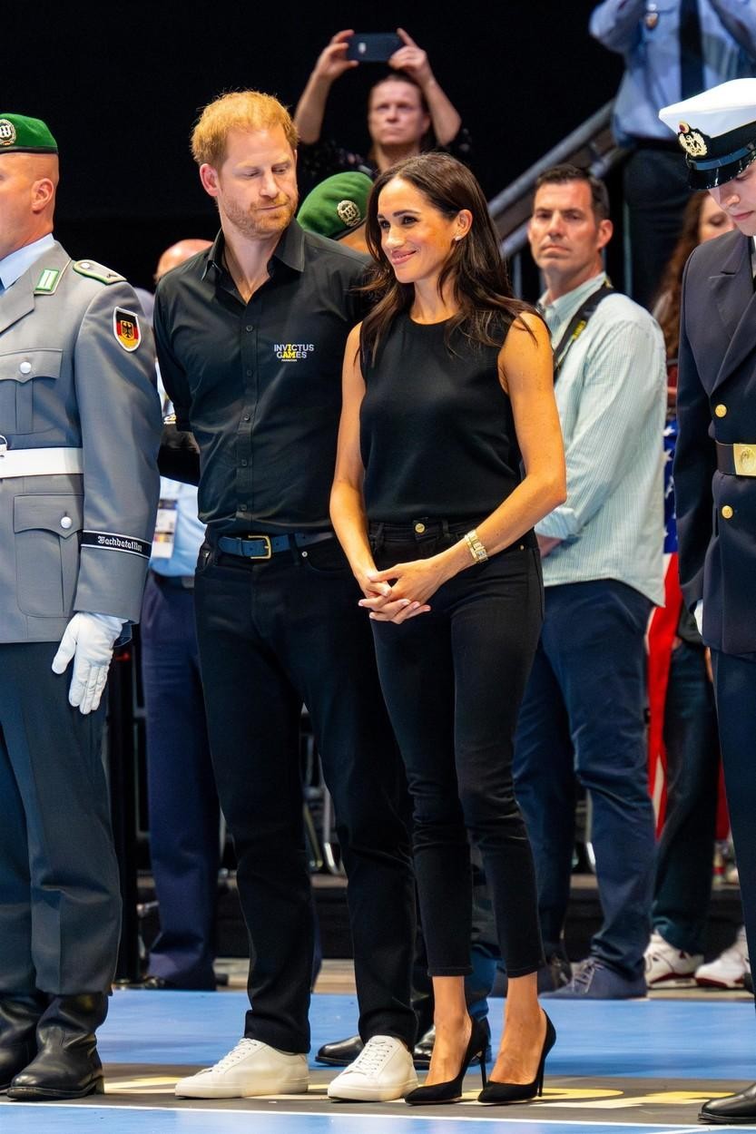 Meghan je nosila pleten brezrokavnik, oprijete kavbojke in semiš pete. Dopolnila se je le z drobnim zlatim in diamantnim nakitom …