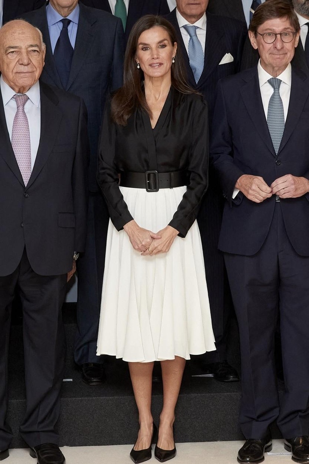 Pod suknjičem je španska kraljica nosila črno svileno bluzo s srednje dolgim ​​belim krilom. Kraljevski videz je popestrila s klasičnim …