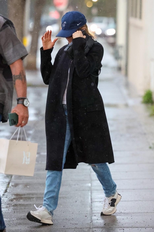 Preprost videz, ko ne veste, kaj obleči: ravne kavbojke, bele superge in črna jakna (kot dodatek dobra kapa). Jennifer Aniston …