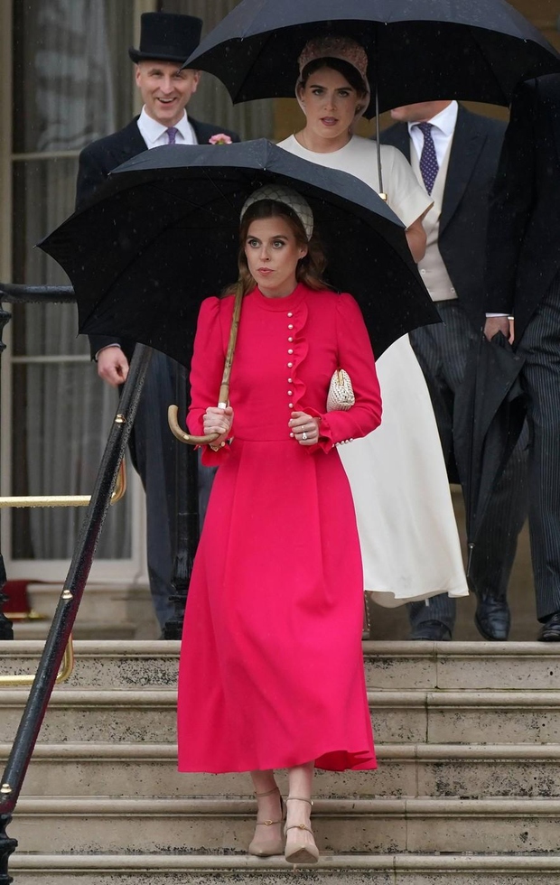 Beatrice je deževni dan popestrila v živahni obleki v barvi fuksije, ki je imela biserne gumbe in nabrane detajle ob …