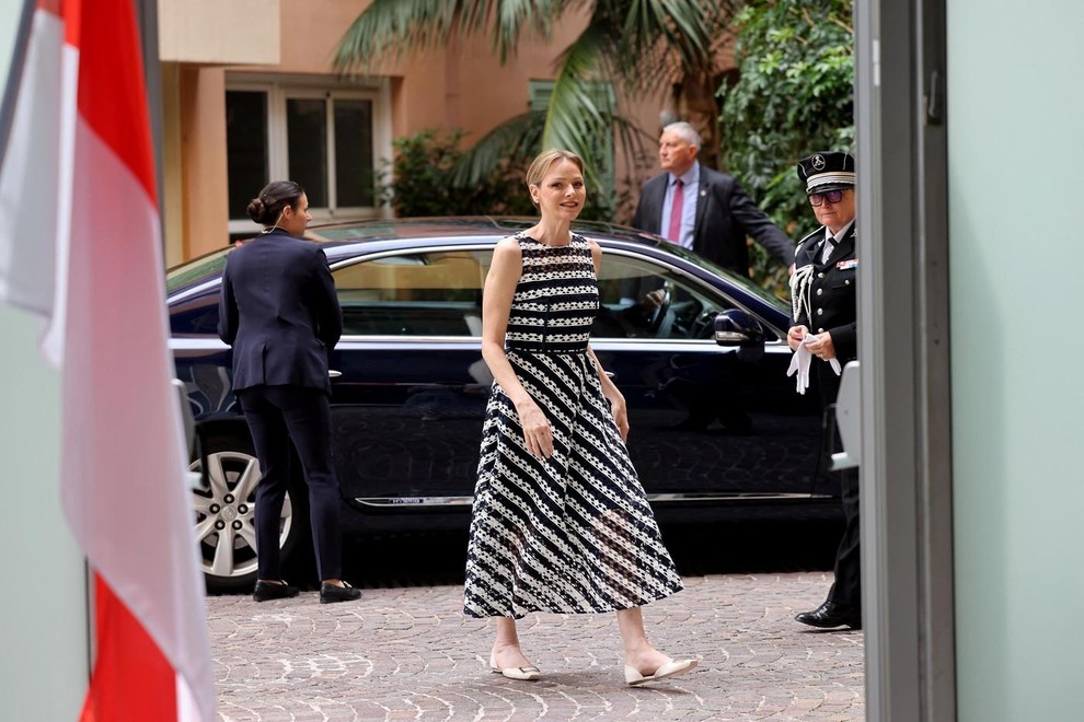 Princesa Charlene je na bazen prišla v obleki švicarske modne hiše Akris. Brezrokavna obleka s črno-belimi črtami zgoraj lepo poudari …