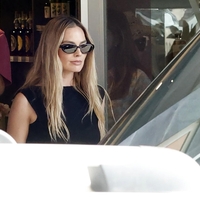 Materinski sijaj Margot Robbie: na plaži navdušila v elegantni črni obleki