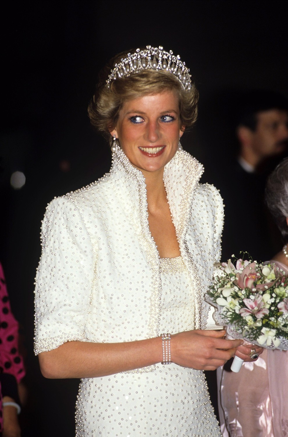 Beli komplet s perlicami in “Elvisovim” ovratnikom (1989) Med obiskom Hongkonga je Diana nosila bleščeč bel komplet obleke in zgornjega …