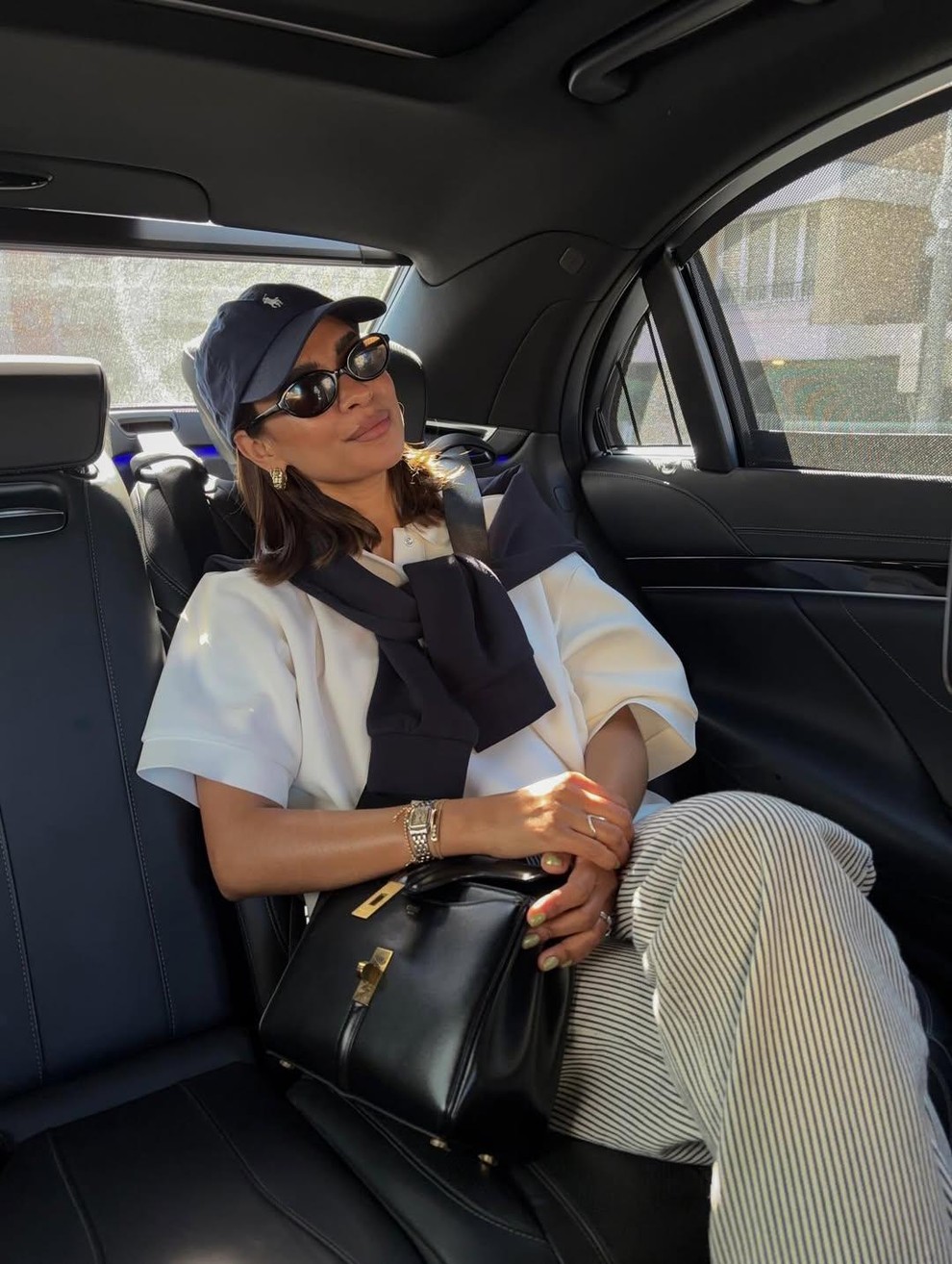 oversized strukturirana bela majica + lanene črtaste hlače + kontrasten pulover, zavezan čez ramena